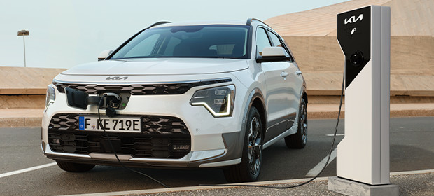 Kia Charge, Fahrzeug an Ladesäule, Frontansicht