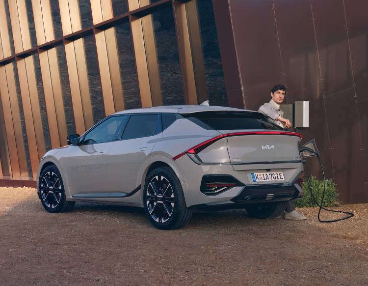 Ein Mann, der seinen Kia EV6 zu Hause  lädt.