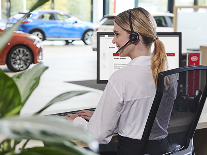 Kia service representative sitting at Kia service desk