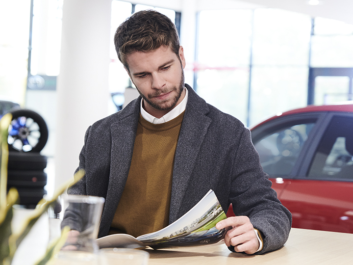 Une femme lit une brochure pendant qu'elle attend