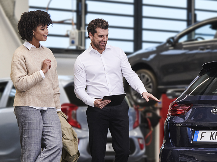 Mechanic shows the customer a genuine part from Kia