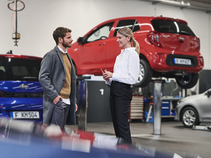 Kia service representative handing over keys to customer