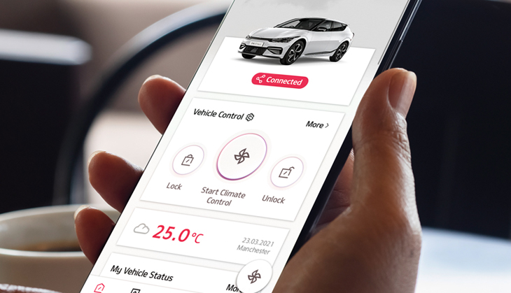 A person navigating a Kia in car technology from the palm of their hand with Kia Connect app