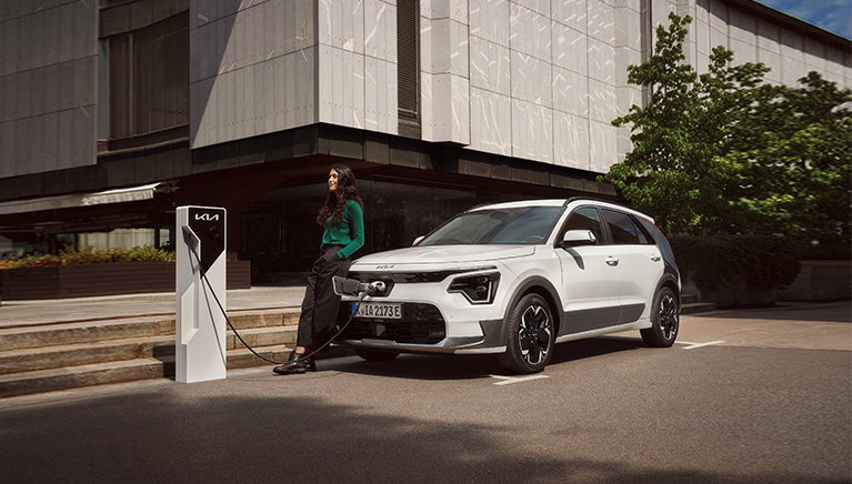 Kia niro EV charging with model sitting on car