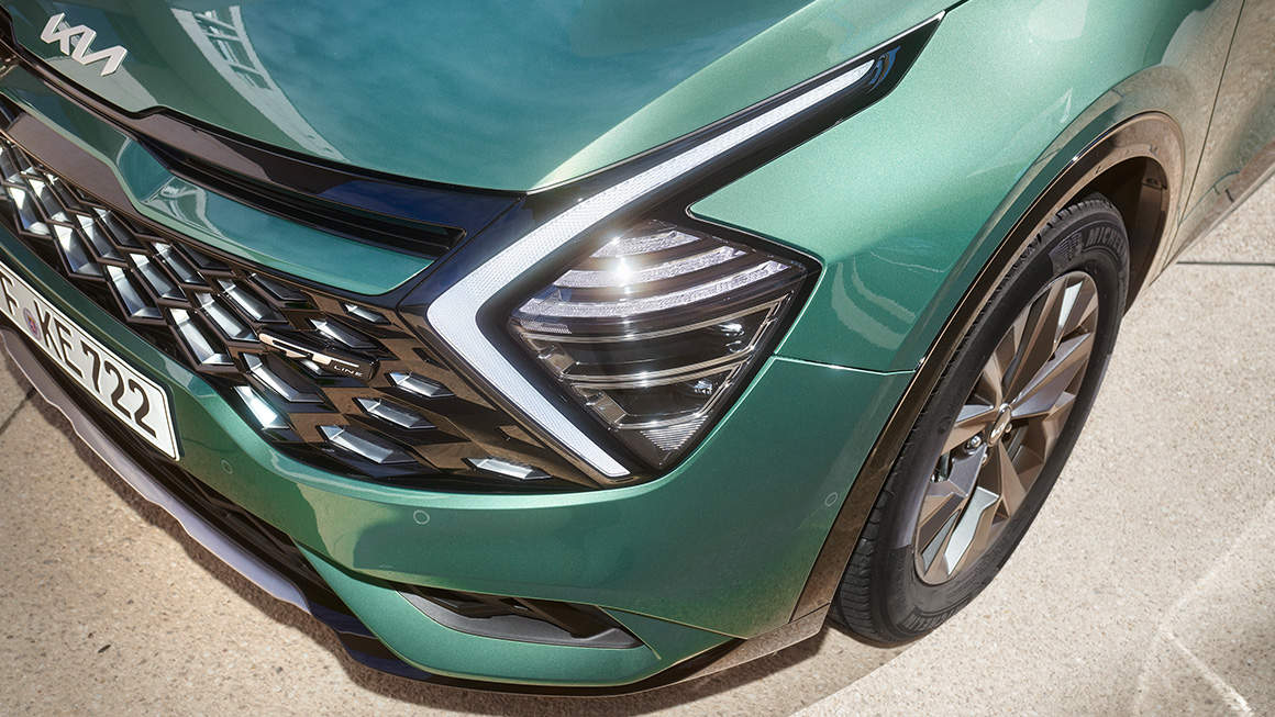 Close-up of the Kia Sportage headlamps, boomerang-shaped LED Daytime Running